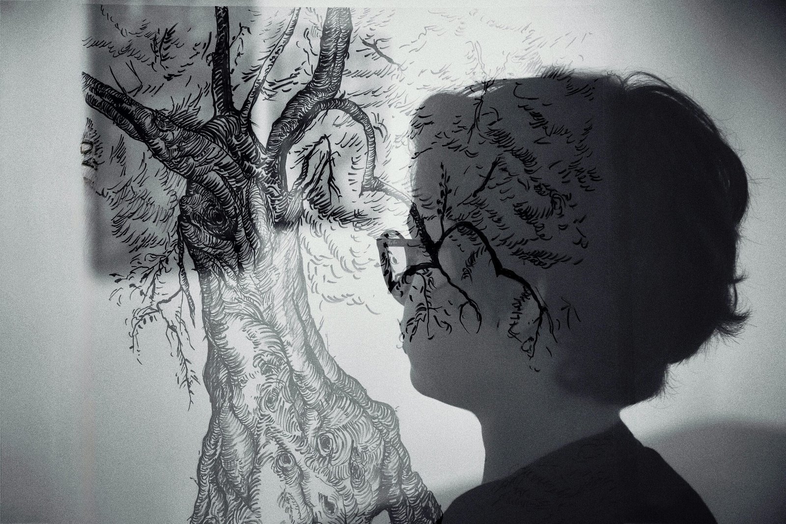 Artistic double exposure of a person and tree sketch creatively blending nature and humanity.